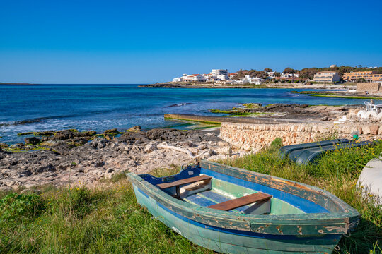 View of Playa Punta Prima and rowing boat on sunny morning, Punta Prima, Menorca, Balearic Islands, Spain
