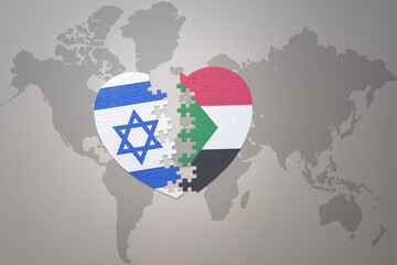 puzzle heart with the national flag of sudan and israel on a world map background.Concept.
