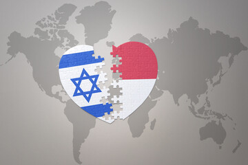 puzzle heart with the national flag of indonesia and israel on a world map background.Concept.