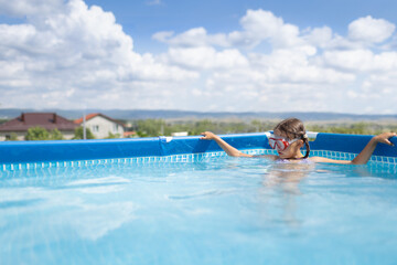 Girl child bathes in the pool