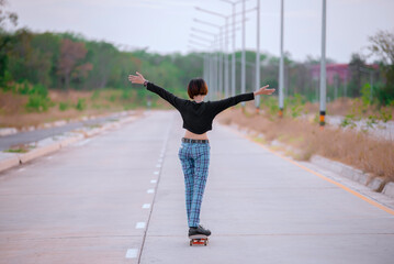 Asian woman play skateboard at the park,Punk girl style