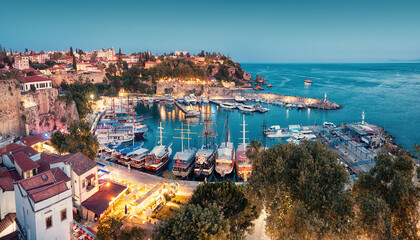 Obraz premium Aerial night view of the picturesque harbor with marina port with cruise tourist ships near the old town of Kaleici in Antalya. Turkish Riviera and travel in resort paradise