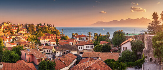 Panoramic scenic rooftop cityscape view of Antalya resort old town and blue sea in the background.