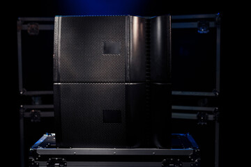 Switched two sound speakers on the background of boxes with concert equipment