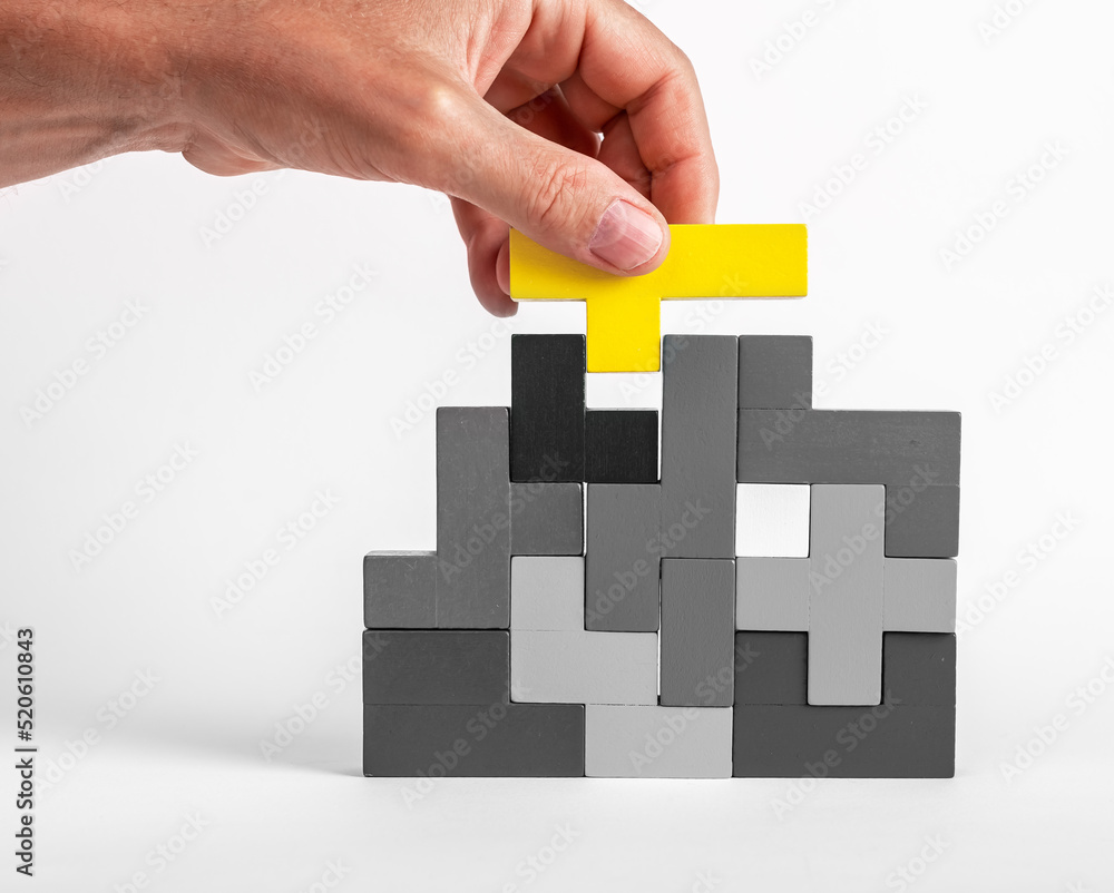 Poster hand putting outstanding yellow element in tetris puzzle. formation concept. creative unique idea. l
