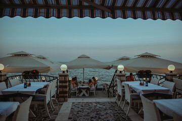 Photo of the restaurant on the background of the sea. Dinner, ev