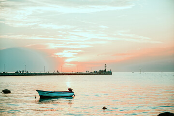 Boat in the sea against the backdrop of a pink sunset. Leisure a