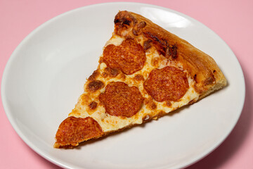 Pizza slices on a plate on a pink background. Pizza with sausage. Fast food