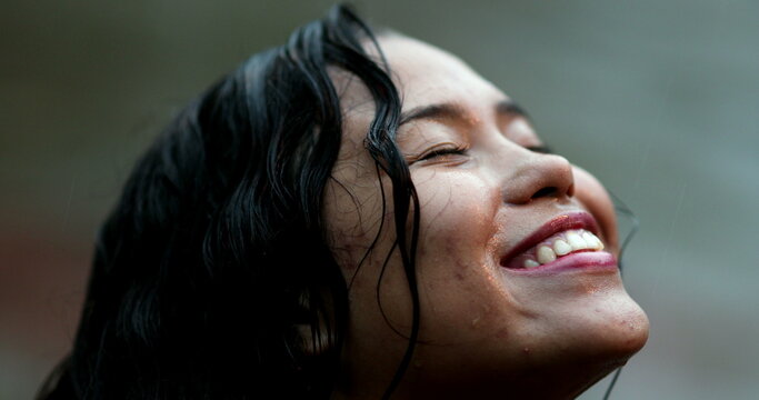 Happy young woman face feeling the rain droplet on face outside