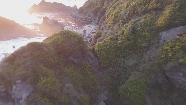 Top view of the green rocky coastal cliffs during susnet