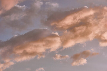 Heavenly landscape background with the texture of clouds at sunset. Beautiful morning sky in blue and orange colors.