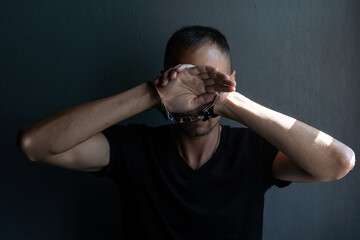 male hands in handcuffs black background