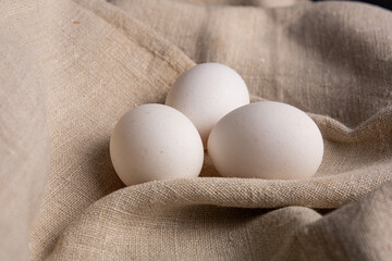 Chicken white eggs on burlap. Farm products. Natural eggs. Chicken eggs on the table.