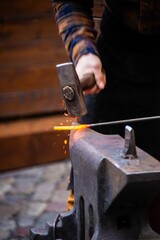 Man striking hot iron with a hammer on the Anvil © Dan Lambert Photography/Wirestock Creators