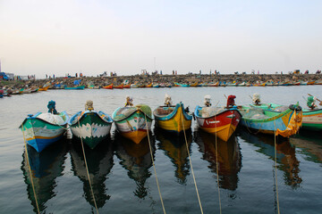 Boats tied together near coastal landscape.