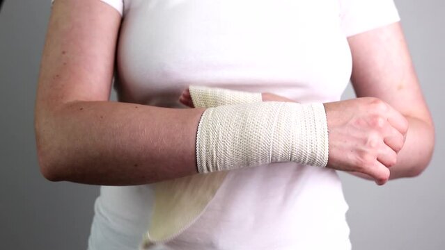 Wrapping applying elastic stretchable bandage on wrist hand trauma, injury closeup
