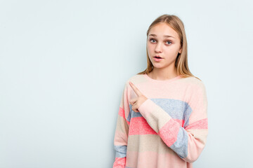 Fototapeta premium Young caucasian girl isolated on blue background pointing to the side