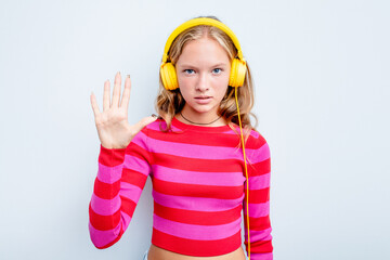 Caucasian teen girl listening to music isolated on blue background smiling cheerful showing number five with fingers.