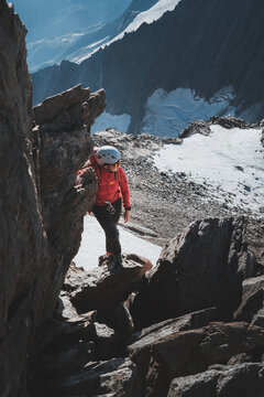Vertical shot of female climber resting on exposed ledge