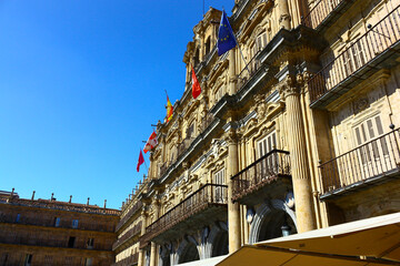 Side view of the main facade of the Salamanca City Hall in Spain in a sunny day with flags in the balcony