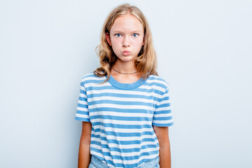 Caucasian teen girl isolated on blue background blows cheeks, has tired expression. Facial expression concept.