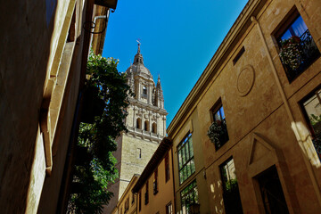 Bottom view of the tower of the cathedral of Salamanca in Spain between the buildings of the city