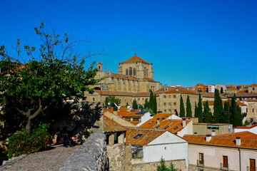 View of the San Esteban convent in Salamanca, Spain, from the Calisto y Melibea garden on a sunny day with a bright blue sky