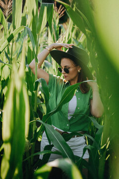 Portrait of stylish woman in jungle - corn plantation. Girl in hat