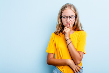 Caucasian teen girl isolated on blue background looking sideways with doubtful and skeptical expression. - obrazy, fototapety, plakaty