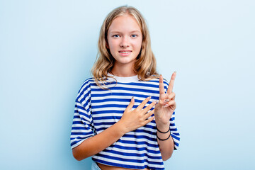Caucasian teen girl isolated on blue background taking an oath, putting hand on chest.