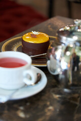 A cup of tea and a cake are on the table