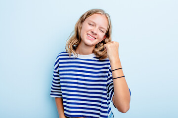 Caucasian teen girl isolated on blue background celebrating a victory, passion and enthusiasm, happy expression.
