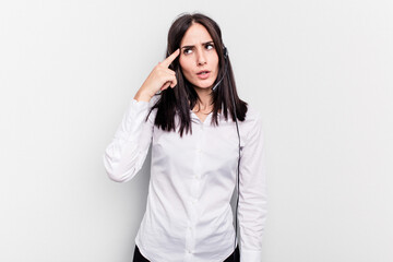 Telemarketer caucasian woman working with a headset isolated on white background showing a disappointment gesture with forefinger.