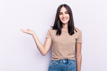 Young caucasian woman isolated on pink background showing a copy space on a palm and holding another hand on waist.