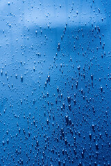 Naklejka na ściany i meble Water drops blue background. Droplet splash rain texture. Drop splash water pattern. Selective focus.