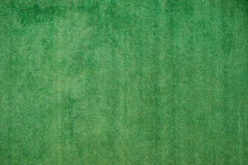The texture of green artificial grass.Covering for sports stadiums and decorations.