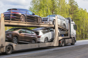 Fototapeta na wymiar Car transporter transports cars on road