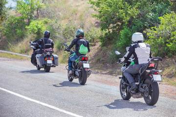 Bikers on motorcycles ride on road