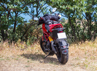 Obraz premium Motorcycle on the field near the trees