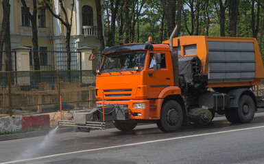 Watering machine washes the street