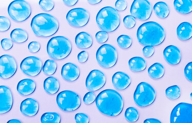 Texture of blue gel on a pink background as a background of cosmetics, hygiene and science close-up. Cosmetic serum, serum drops