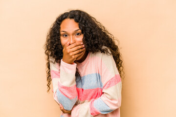 Young hispanic woman isolated on beige background scared and afraid.