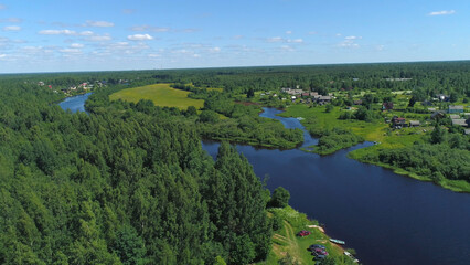 Natural landscape with green trees, wide river, and green field. Shot. Aerial view of summer landscape with forest, green meadows and river in countryside, aero adventure in a summertime.