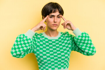 Young caucasian woman with a short hair cut isolated focused on a task, keeping forefingers pointing head.