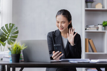 Happy young Asian woman using the phone texting messaging on a smartphone, smiling girl using cellphone chatting, browsing wireless internet on gadget at work please