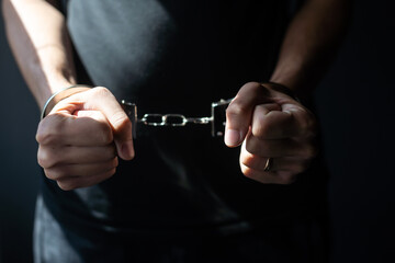 male hands in handcuffs black background