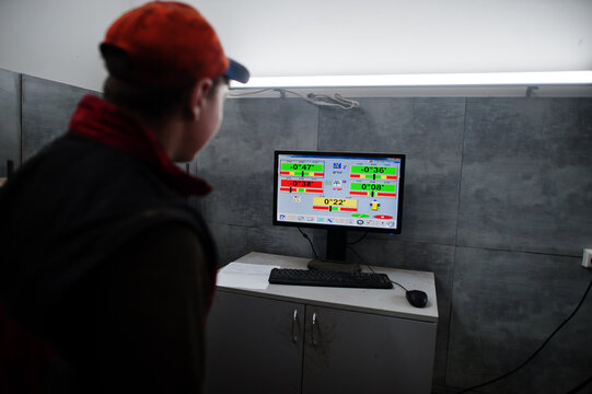 Auto mechanic sets american SUV car for diagnostics and configuration camber check in workshop of service station..