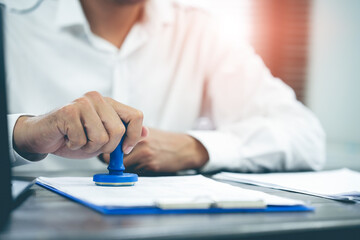 businessman signing approval agreement business contract on contract with an approved rubber stamp...