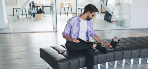 Millennial businessman working on bench in office