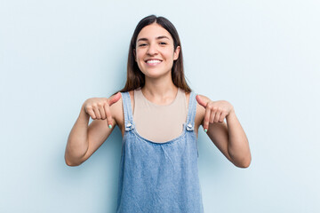 Young caucasian woman isolated on blue background points down with fingers, positive feeling.